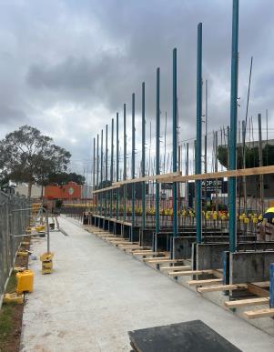 A construction site with vertical beams looking onto the nearby road.