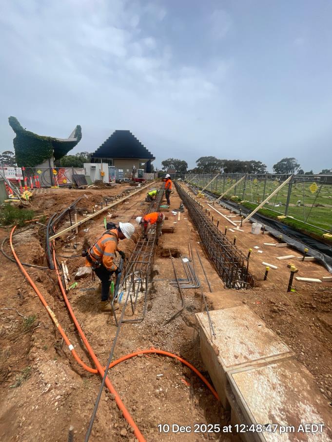 Four construction worker position large steel cages in preparation for a concrete pour. 