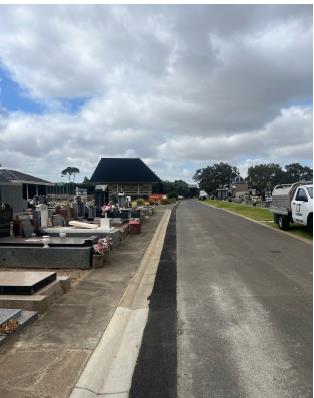 A road with newly asphalted drainage leading to the existing mausoleum 