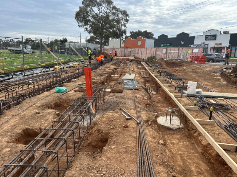 A construction site for a building, with steel cages and holes prepared for the foundations. 