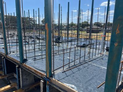 View of a construction site with beams and covered concrete